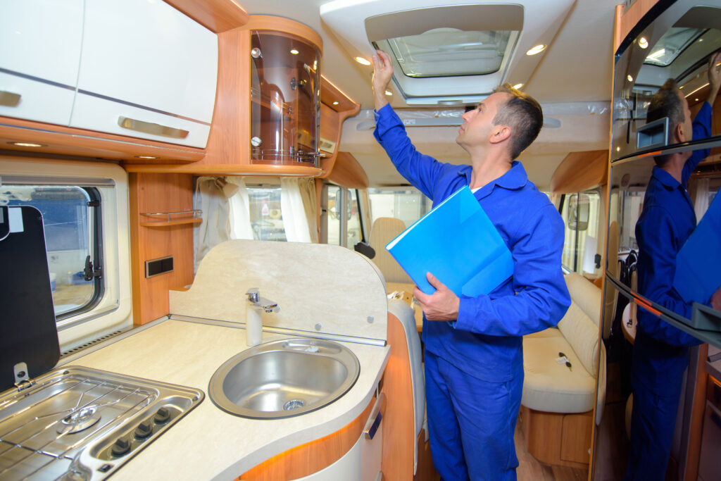 An RV inspector looking at the roof of an RV. When buying an RV for the first time it might be a good idea to hire an inspector. 